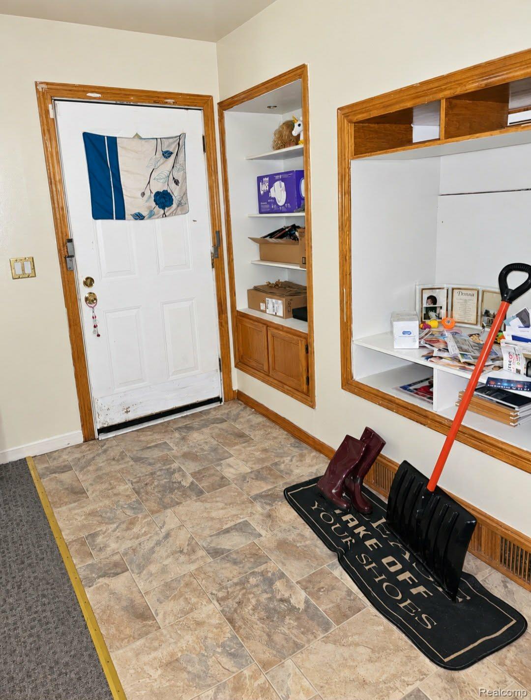 Entryway with wood-finish flooring and built-in shelving