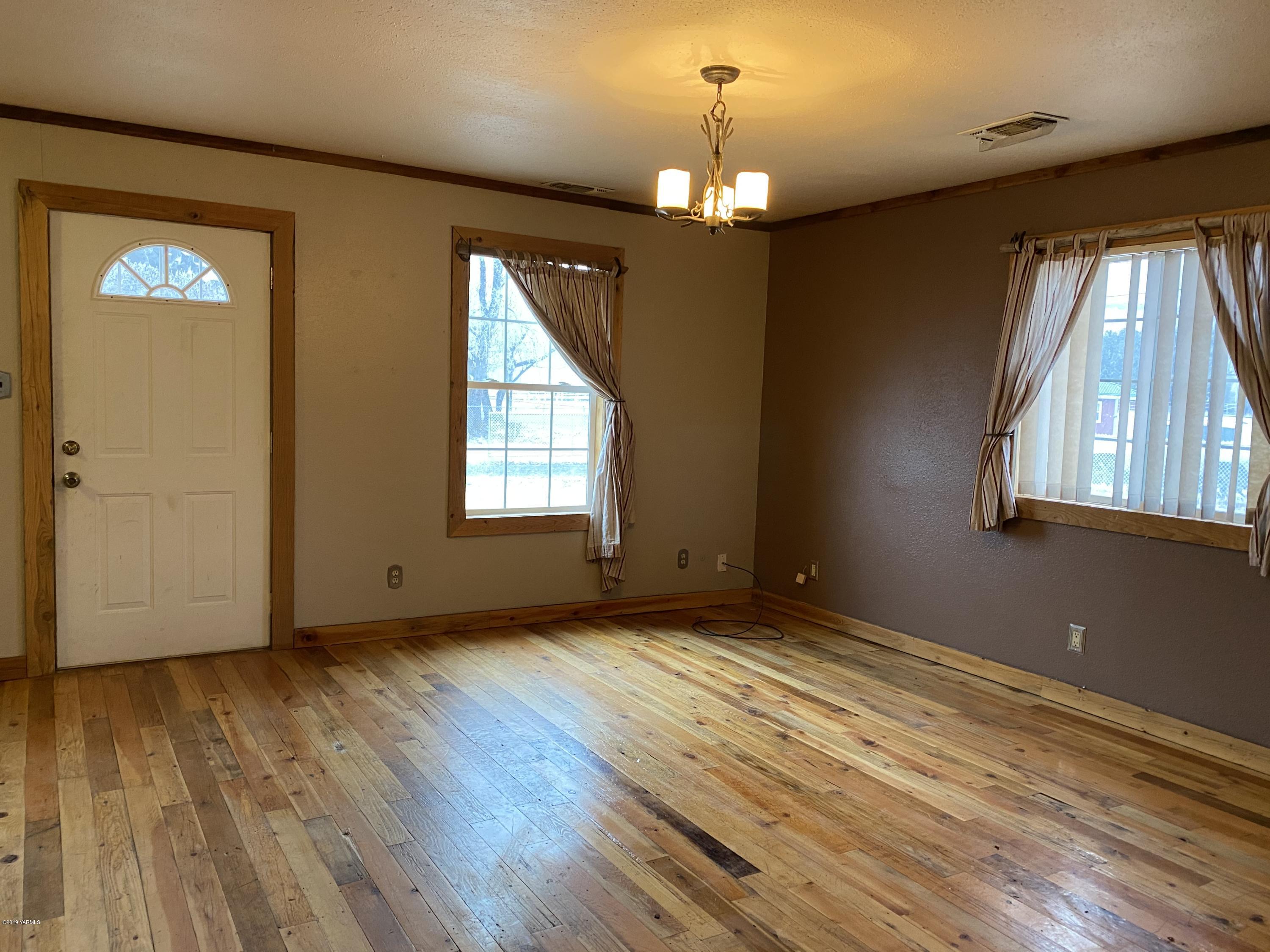 9161 South Naches Road Naches, WA 98937 - Photo 3 of 11 wooden floor in an empty room with a window