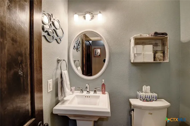 a bathroom with a toilet sink and mirror