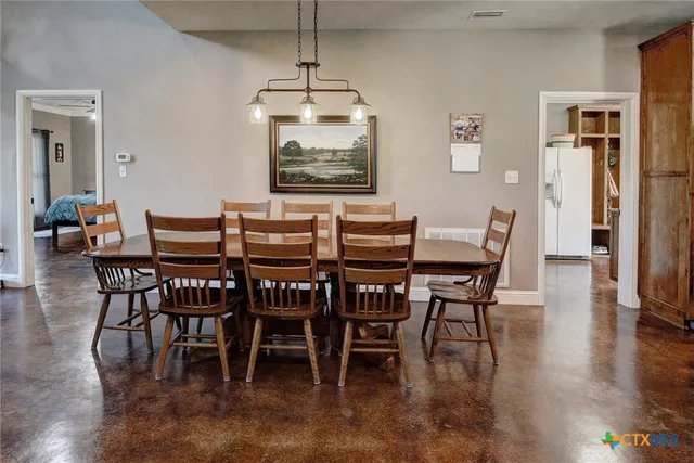 a dining room with furniture a chandelier and wooden floor