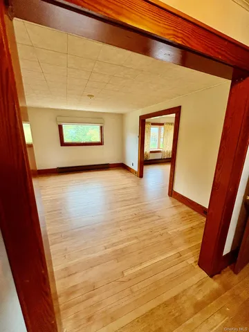 a view of an empty room with wooden floor