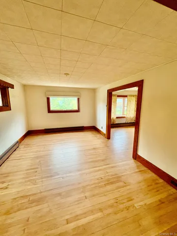 a view of a room with wooden floor and window