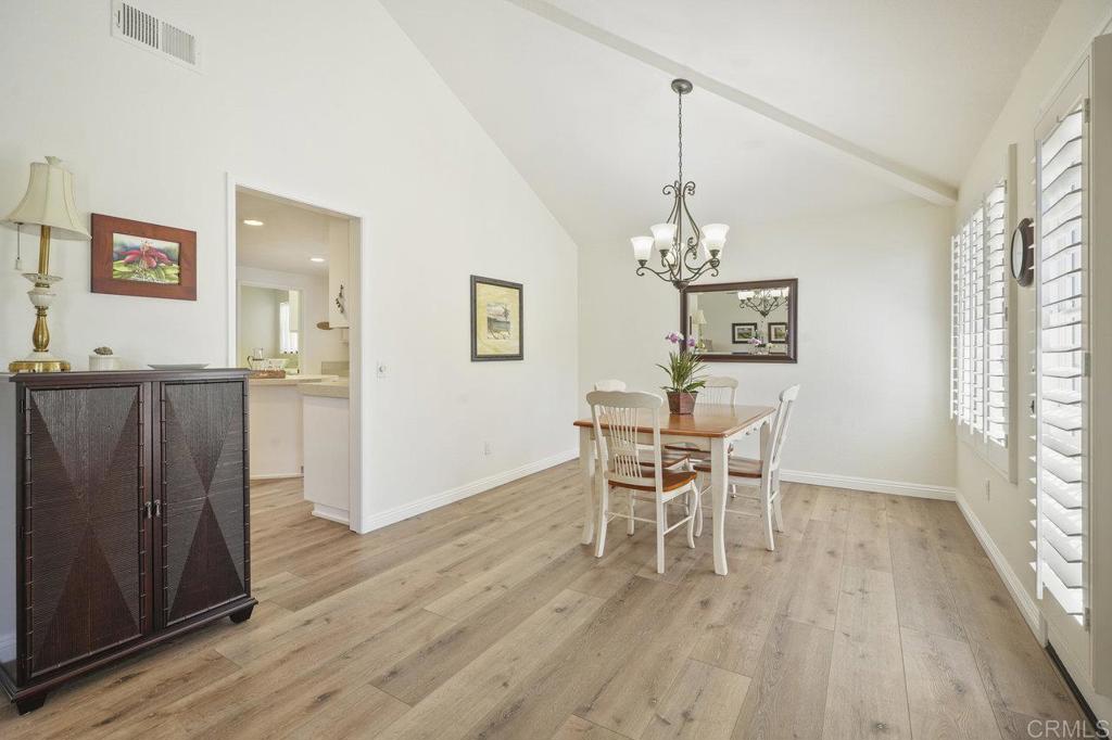 1729 Pinehurst Avenue Escondido, CA 92026 - Photo 12 of 29 a dining room with wooden floor a chandelier a wooden table and chairs