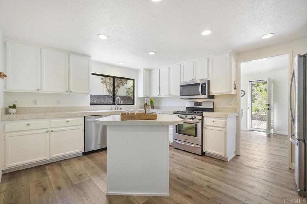 1729 Pinehurst Avenue Escondido, CA 92026 - Photo 15 of 29 a kitchen with granite countertop white cabinets and stainless steel appliances