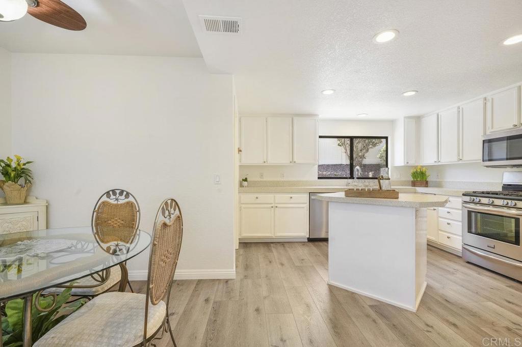 1729 Pinehurst Avenue Escondido, CA 92026 - Photo 17 of 29 a kitchen with a table chairs refrigerator and a stove