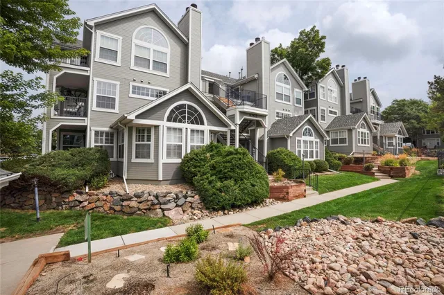 a front view of a house with a yard and potted plants