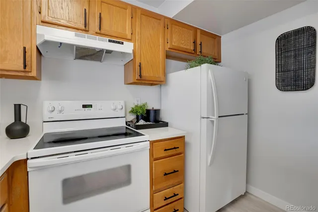 a kitchen with stainless steel appliances white cabinets and a refrigerator