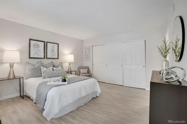 a bedroom with a bed and a painting on the wall