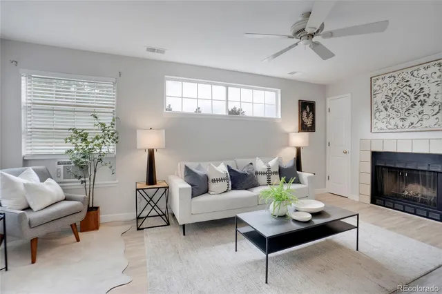 a living room with furniture a fireplace and a window
