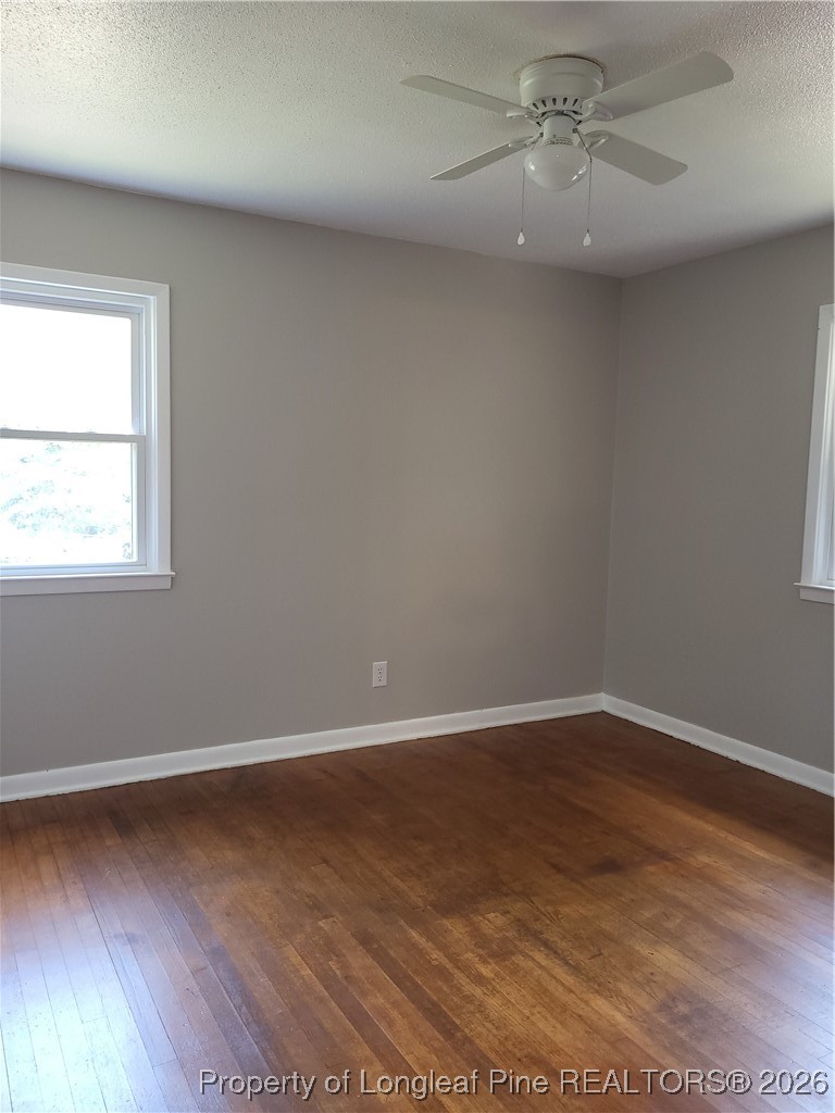182 Summerhill Road Fayetteville, NC 28303 - Photo 23 of 24 an empty room with wooden floor fan and windows