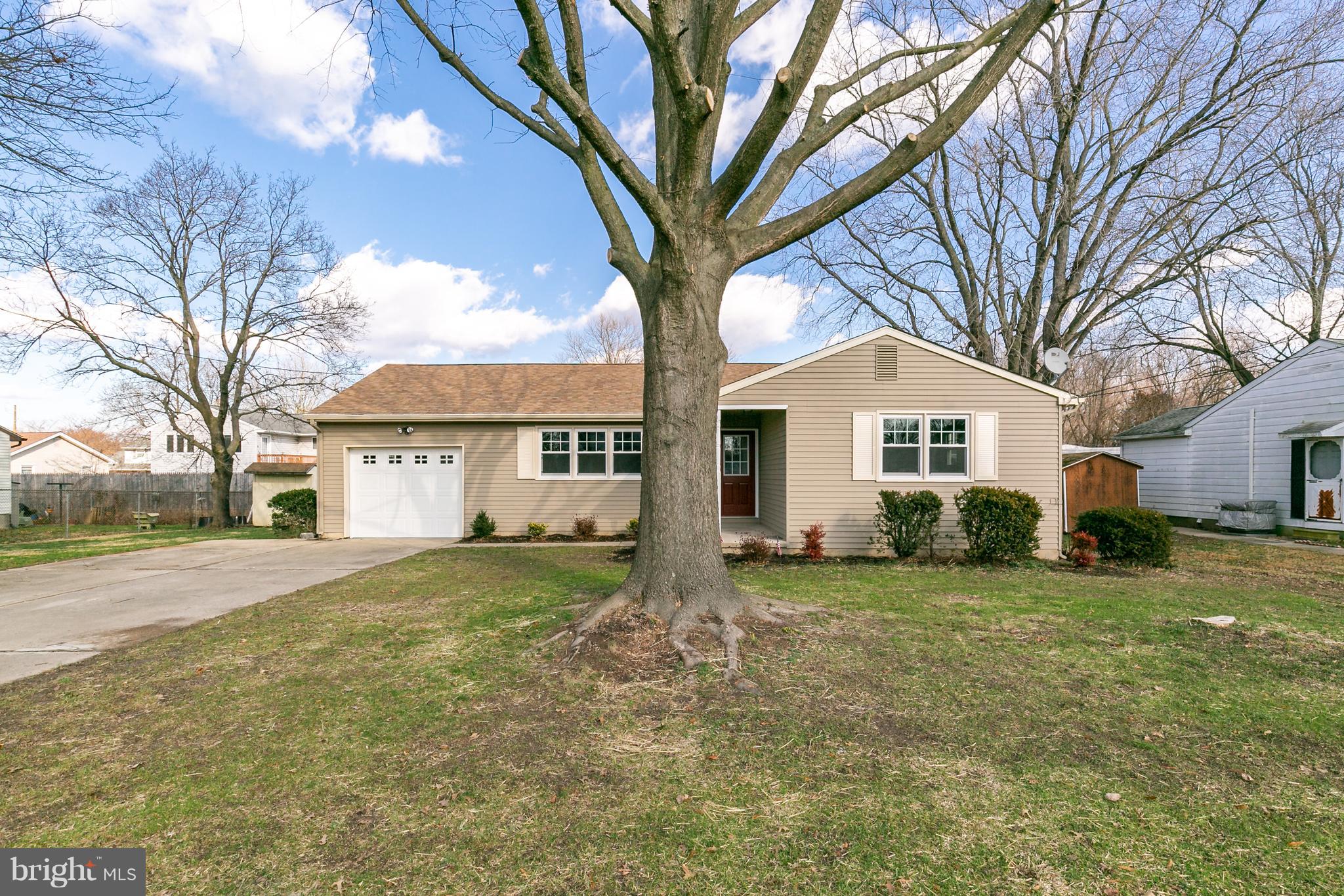 126 Eaton Road Pennsville, NJ 08070 - Photo 2 of 29 a view of a yard in front of a house with a large tree