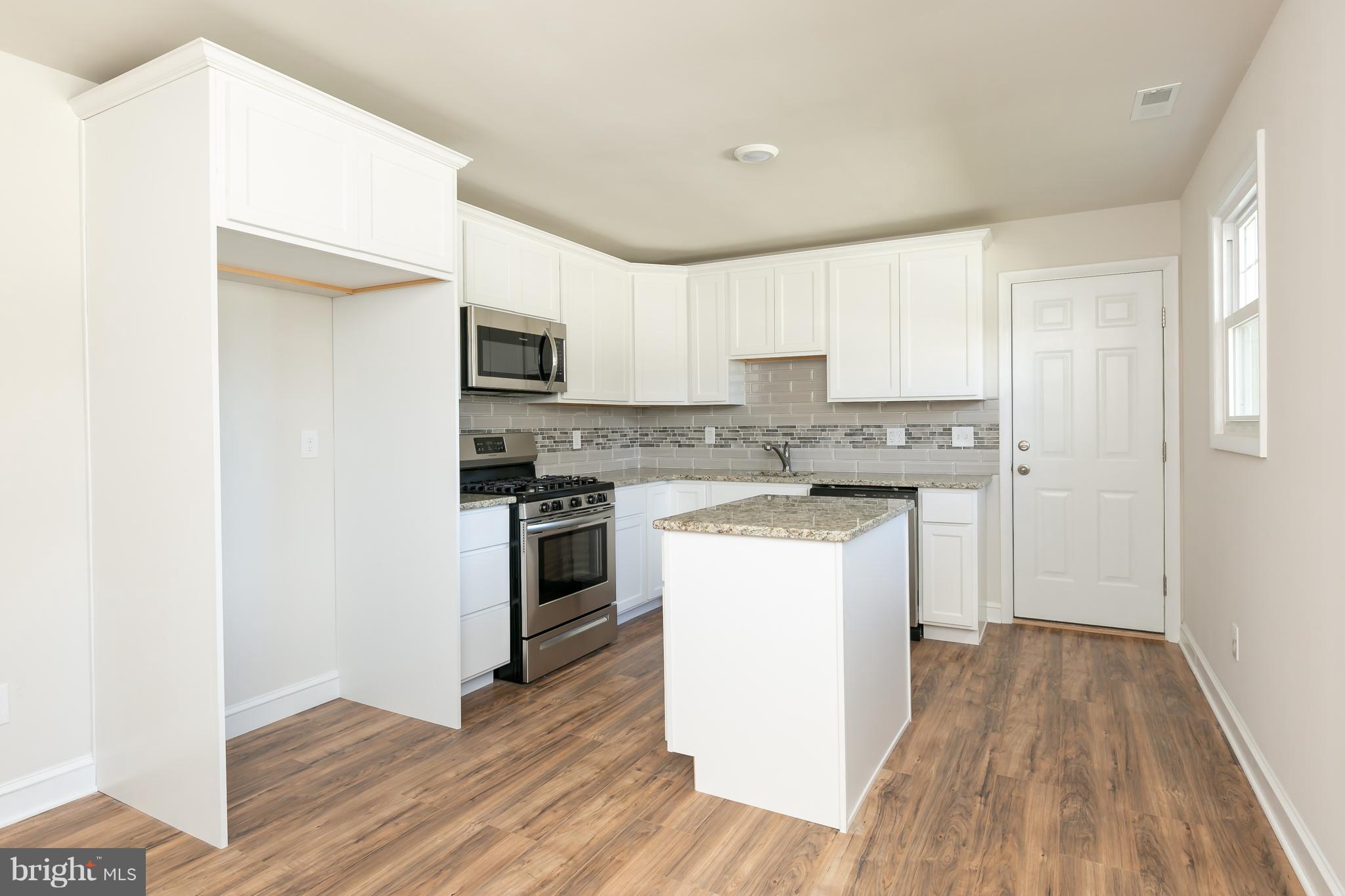 126 Eaton Road Pennsville, NJ 08070 - Photo 12 of 29 a kitchen with a refrigerator stove and wooden cabinets