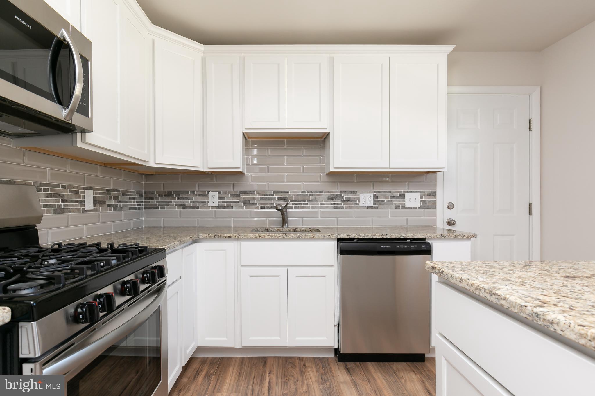 126 Eaton Road Pennsville, NJ 08070 - Photo 13 of 29 a kitchen with granite countertop white cabinets and stainless steel appliances
