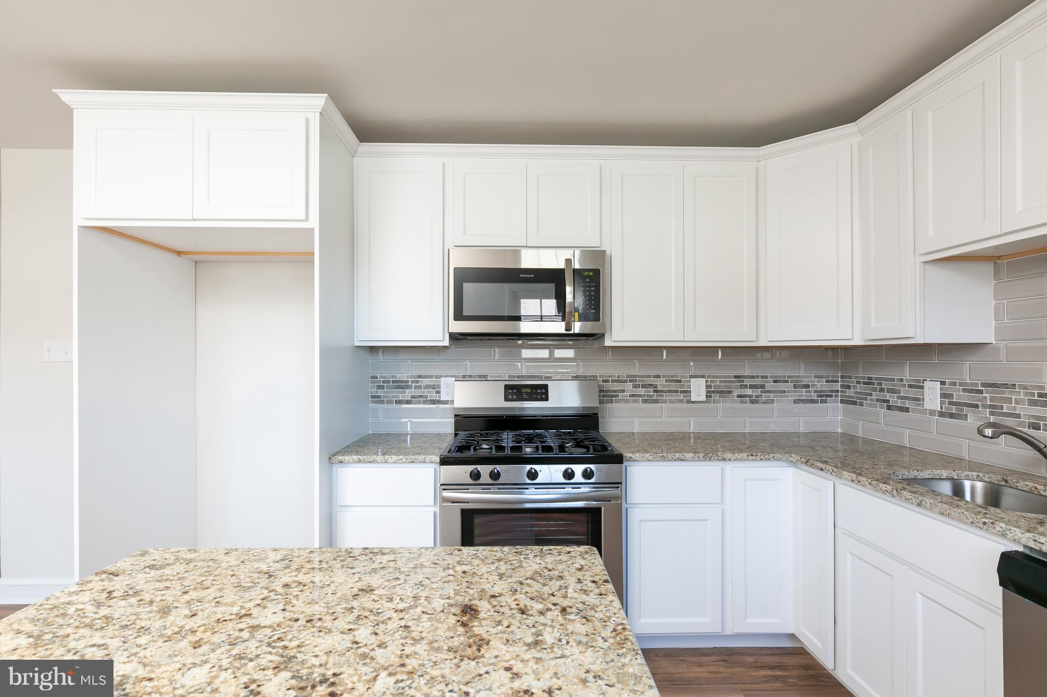 126 Eaton Road Pennsville, NJ 08070 - Photo 15 of 29 a kitchen with granite countertop a stove a sink and a microwave