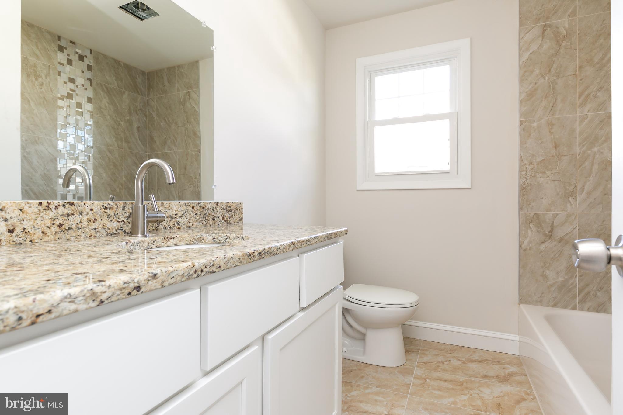 126 Eaton Road Pennsville, NJ 08070 - Photo 23 of 29 a bathroom with a granite countertop sink a toilet and a mirror