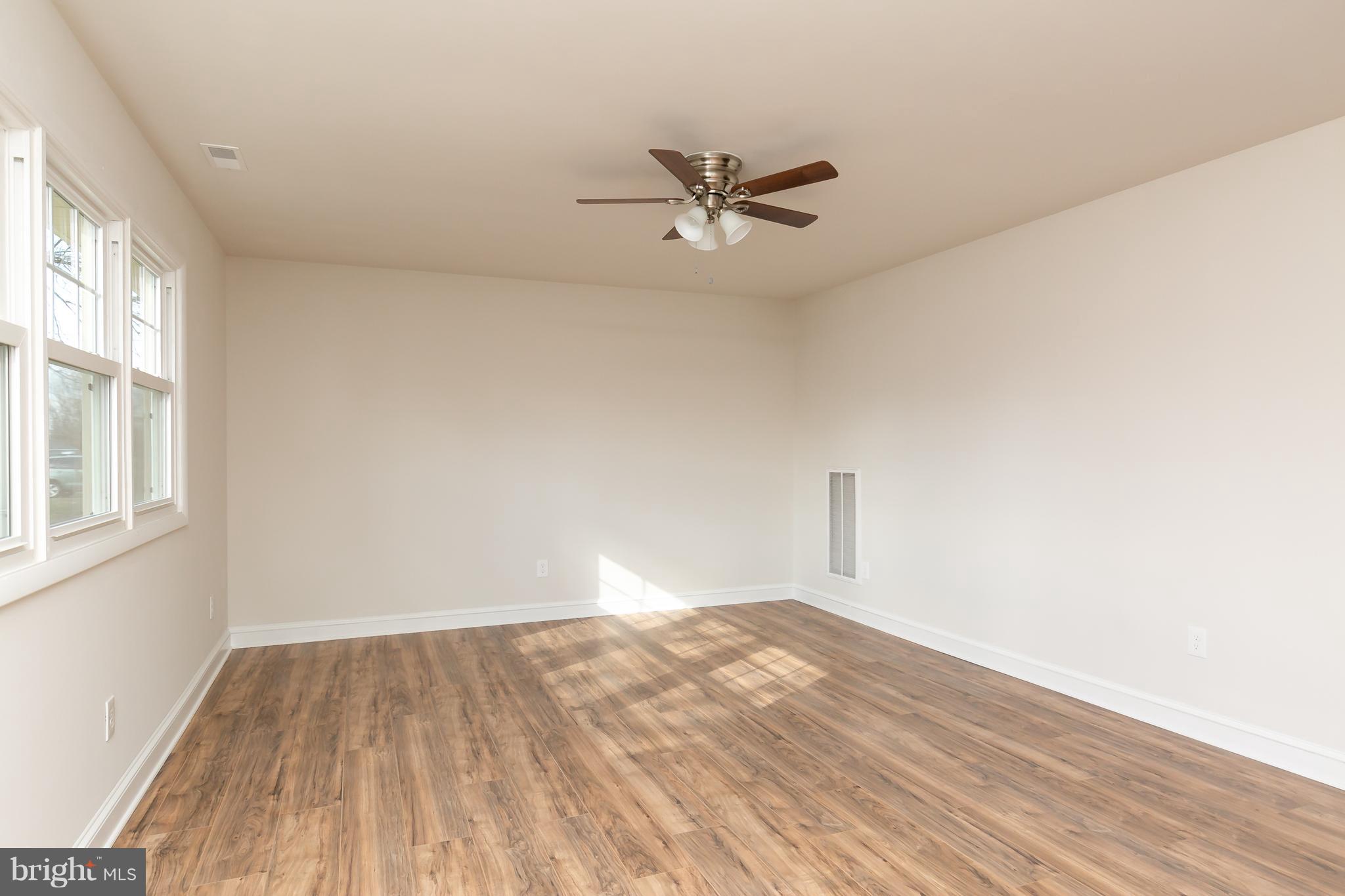 126 Eaton Road Pennsville, NJ 08070 - Photo 6 of 29 a view of empty room with wooden floor and fan