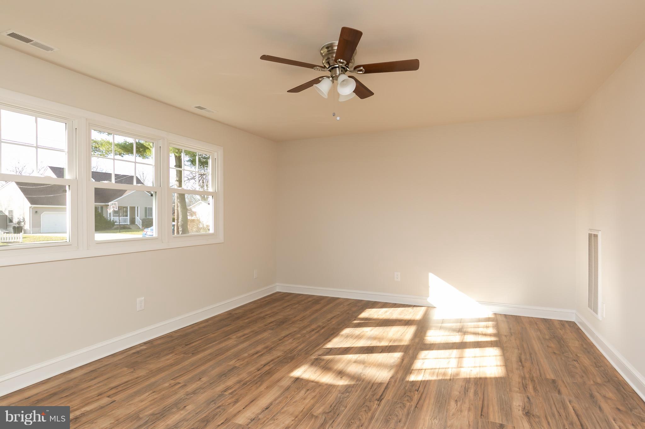 126 Eaton Road Pennsville, NJ 08070 - Photo 7 of 29 a view of empty room with wooden floor and fan