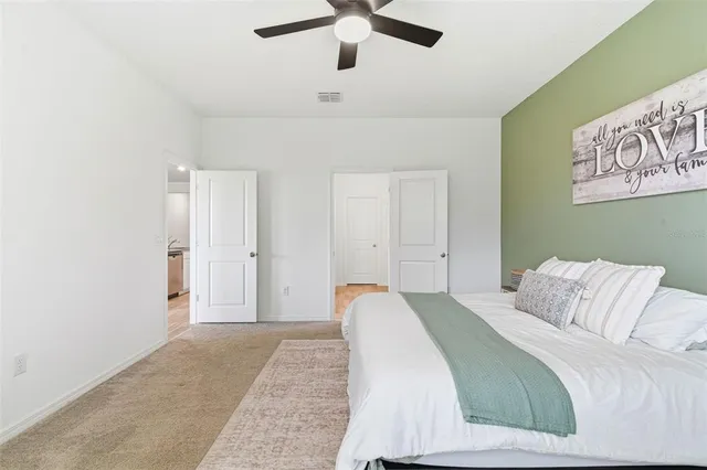 a spacious bedroom with a bed and a chandelier