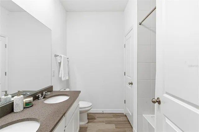 a bathroom with a granite countertop sink a toilet and a mirror