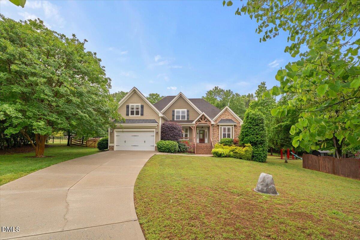 7400 Denlee Road Raleigh, NC 27603 - Photo 3 of 47 a front view of a house with a yard and garage