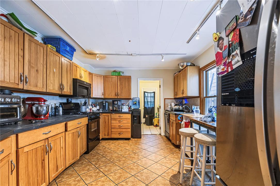1030 Monocacy Street Bethlehem, PA 18018 - Photo 10 of 34 Ample wooden cabinetry and ceramic tile flooring define this functional kitchen space.