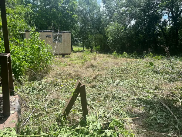 a backyard of a house with lots of green space and wooden fence