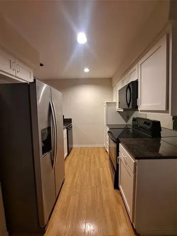 a kitchen with stainless steel appliances granite countertop a refrigerator a stove a sink and a microwave