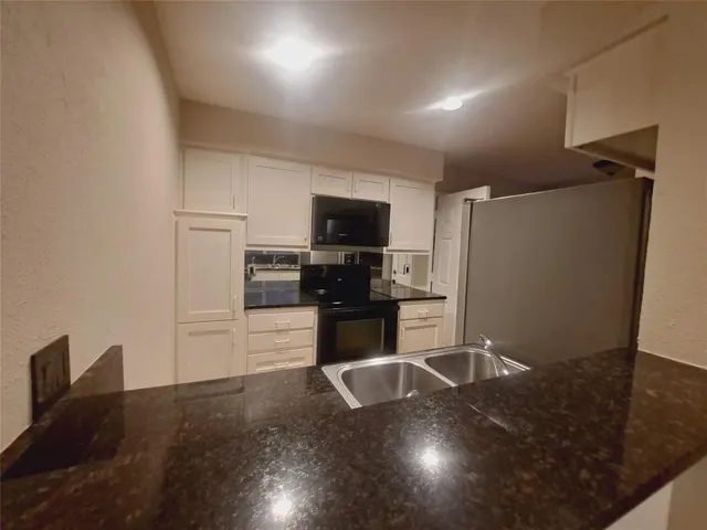 a kitchen with a refrigerator and a stove top oven