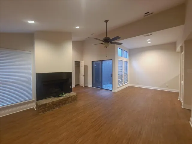 an empty room with a fireplace and a chandelier fan