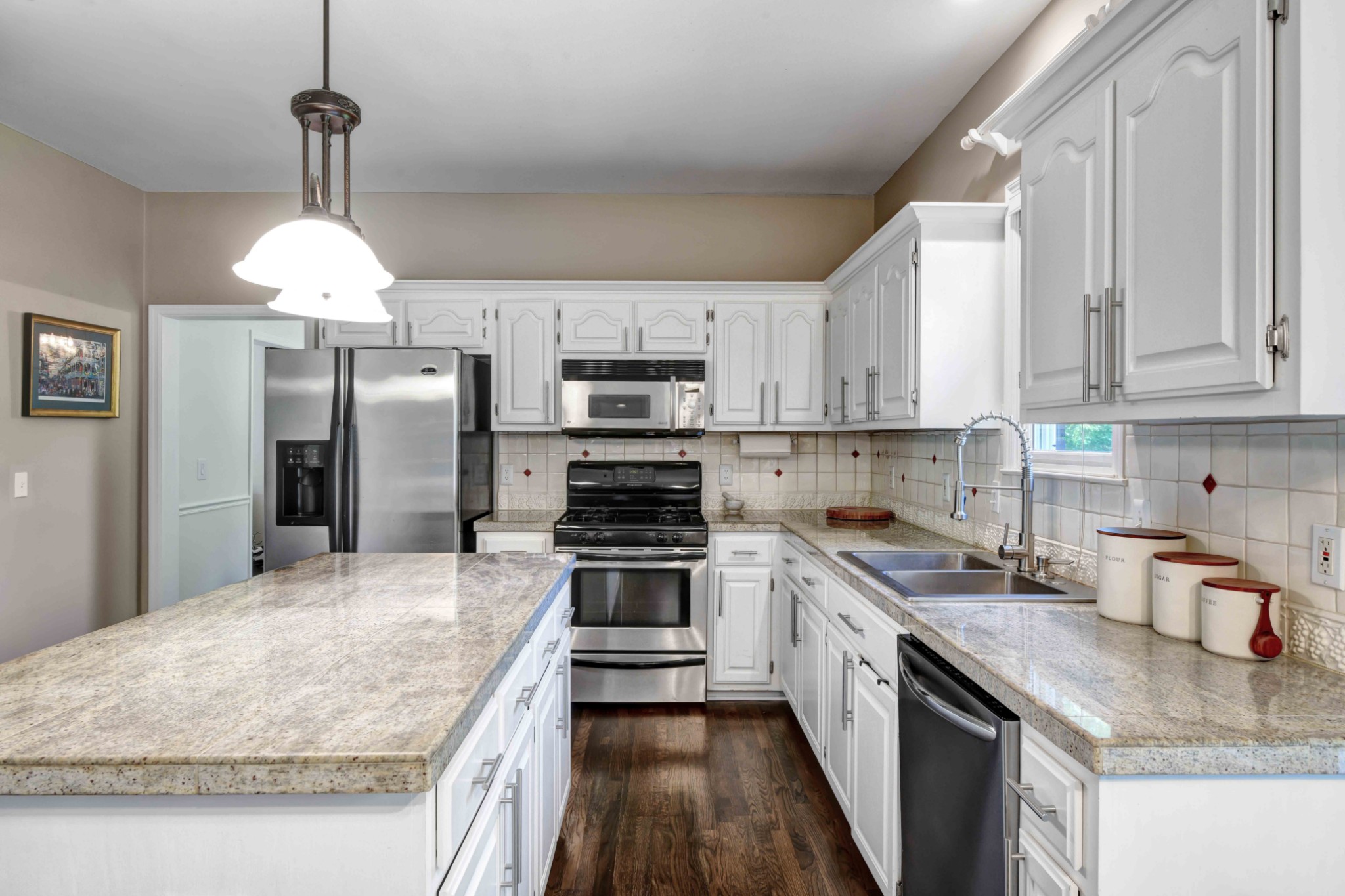 4845 Manassas Drive Brentwood, TN 37027 - Photo 11 of 22 a kitchen with kitchen island granite countertop a sink stove and refrigerator