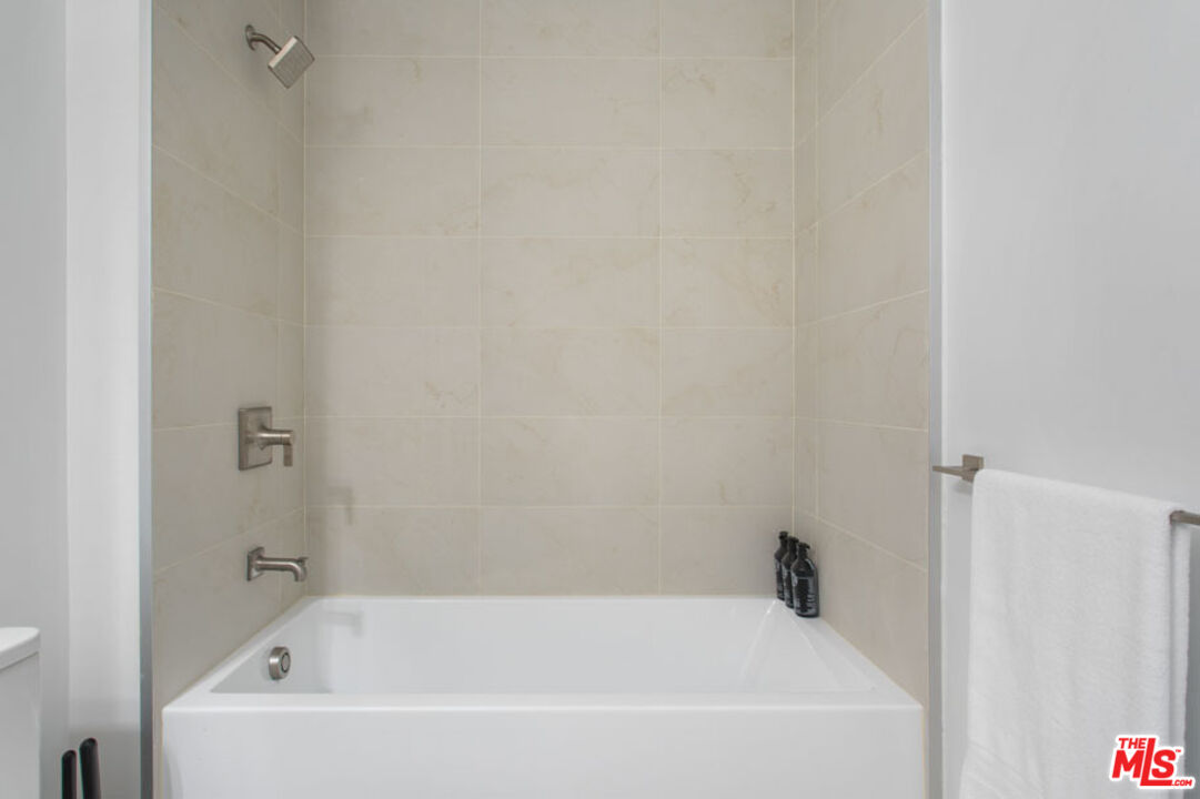 10310 Santa Monica Boulevard, Unit PH710 Los Angeles, CA 90025 - Photo 18 of 38 a white bath tub sitting next to a white wooden wall