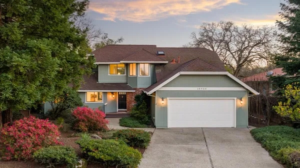 a front view of a house with a yard and trees