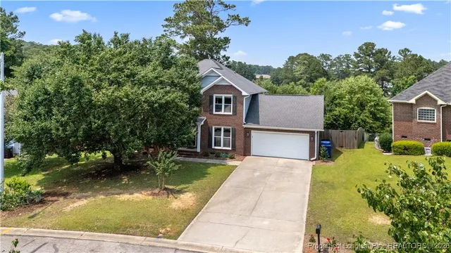 a front view of a house with a yard and trees