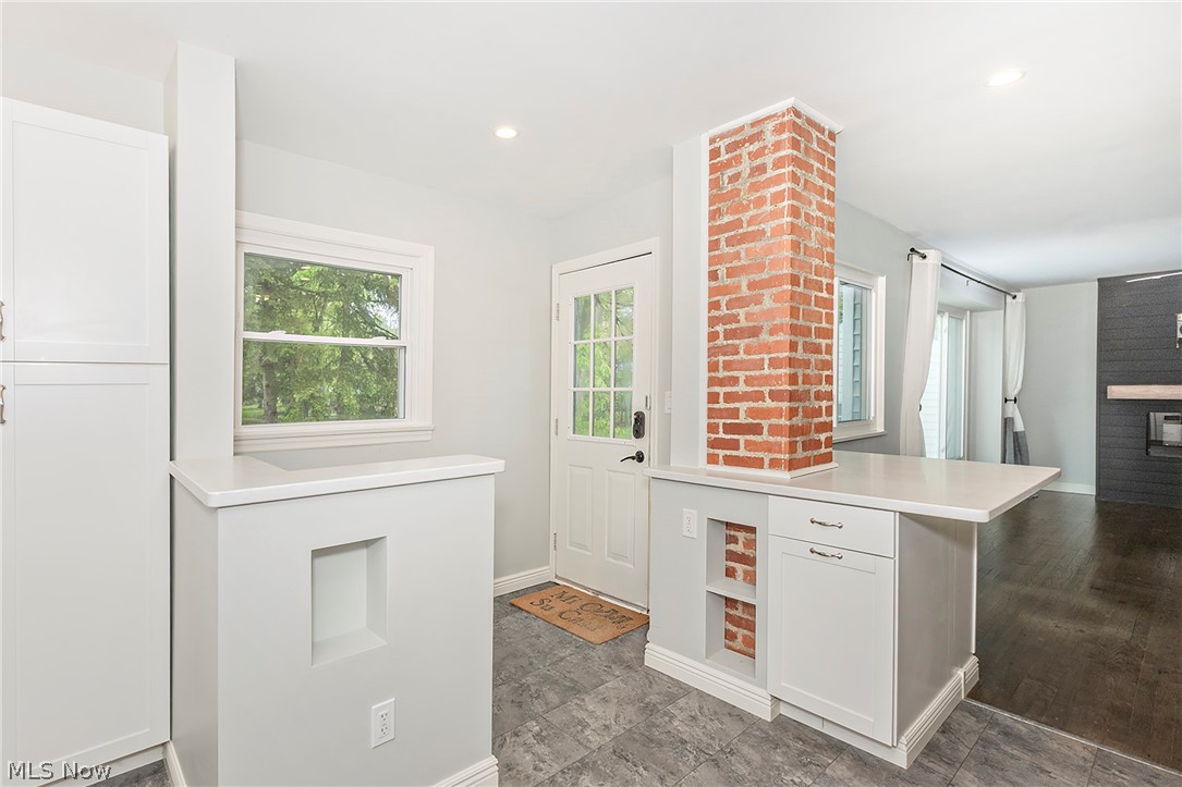 3719 Walter Road North Olmsted, OH 44070 - Photo 10 of 35 Open-concept kitchen area featuring a brick column accent, white cabinetry, integrated shelving, and light countertops