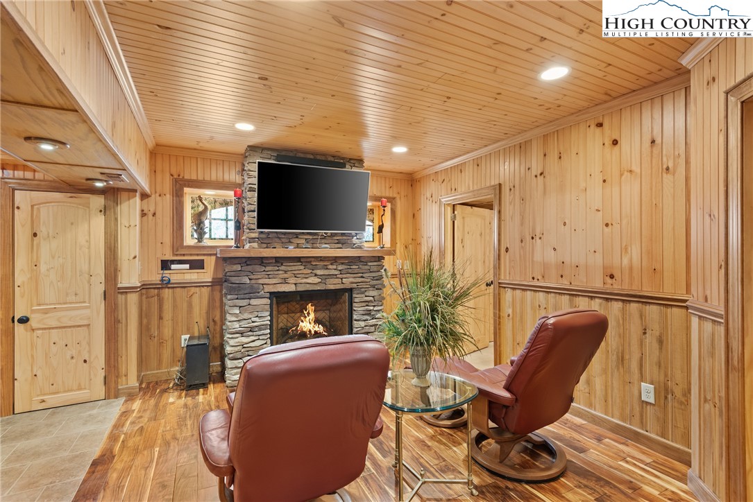 262 Lemly Road Fleetwood, NC 28626 - Photo 19 of 37 a living room with furniture a fireplace and a flat screen tv