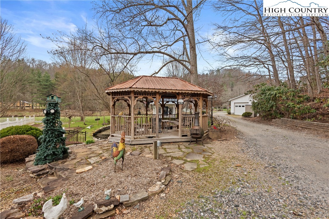 262 Lemly Road Fleetwood, NC 28626 - Photo 34 of 37 a backyard of a house with table and chairs under an umbrella