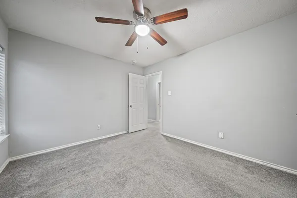 an empty room with chandelier fan