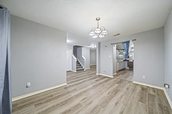 a view of a livingroom with wooden floor and staircase