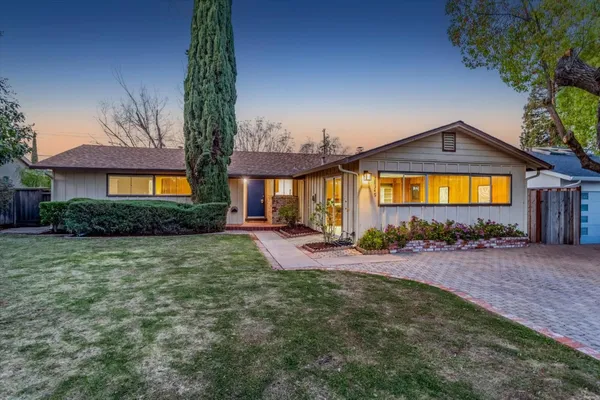 a front view of a house with yard and green space