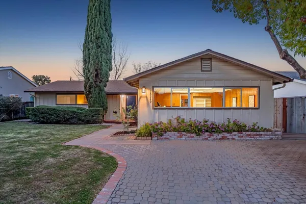 a front view of a house with a yard and outdoor seating