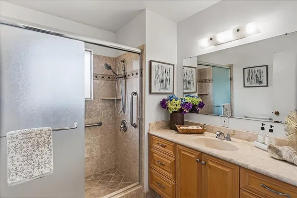 a bathroom with a granite countertop shower sink and mirror