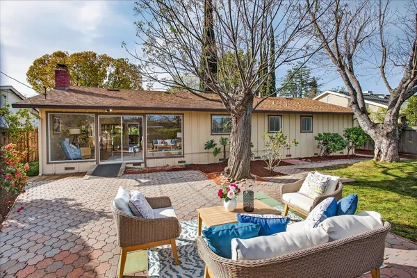 a view of a house with backyard and sitting area