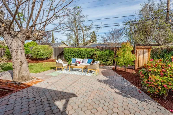 a view of a patio with a table and chairs under an umbrella