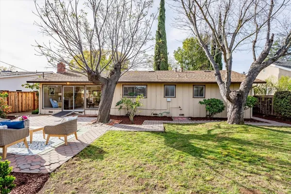 a view of a house with backyard and sitting area