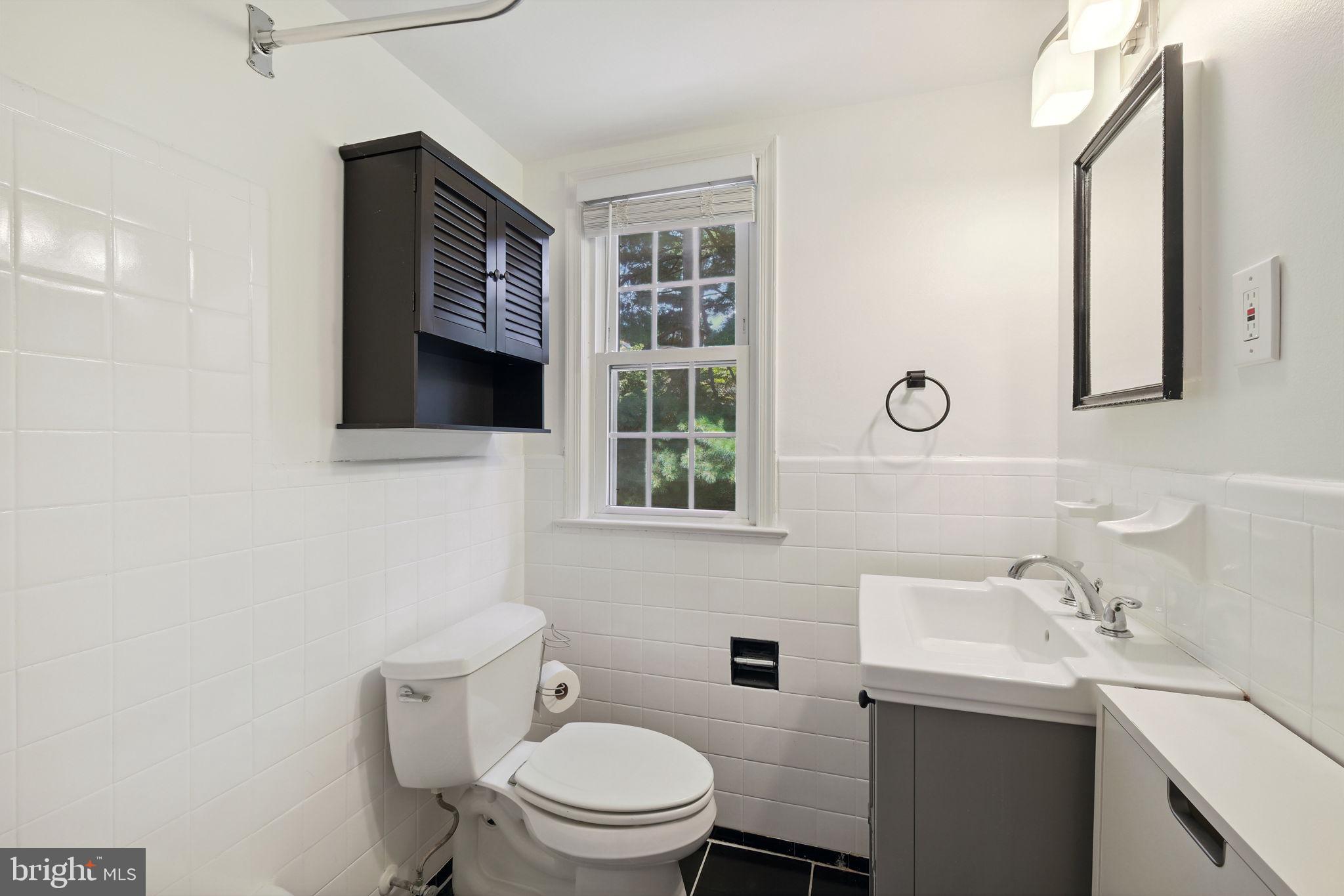 8203 Grubb Road, Unit 201 Silver Spring, MD 20910 - Photo 15 of 26 a bathroom with a toilet sink and mirror