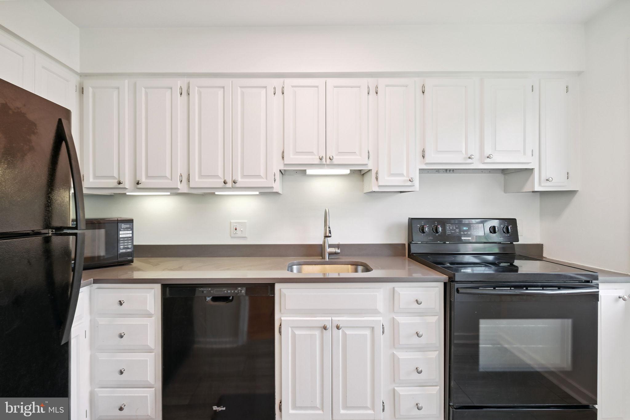 8203 Grubb Road, Unit 201 Silver Spring, MD 20910 - Photo 6 of 26 a kitchen with granite countertop white cabinets and stainless steel appliances