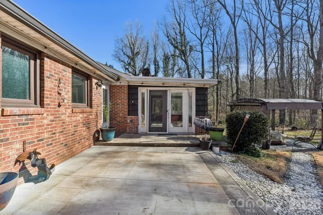 a view of swimming pool with sitting area and trees
