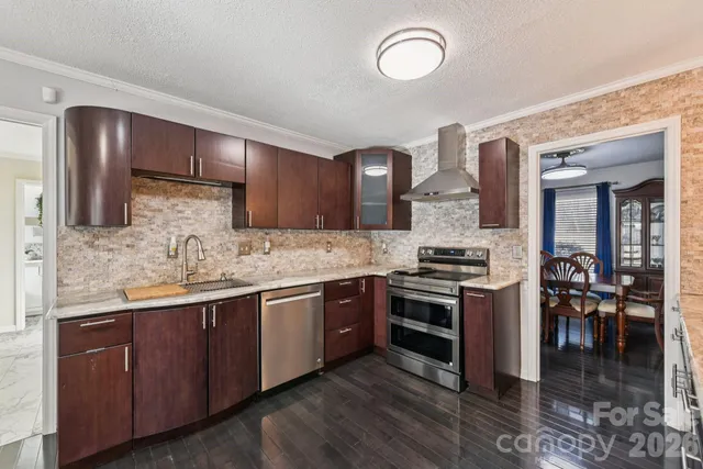 a kitchen with stainless steel appliances granite countertop a stove and cabinets