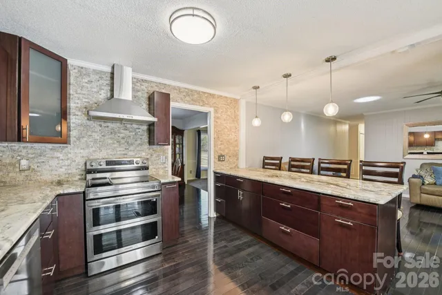 a kitchen with stainless steel appliances granite countertop a stove a sink and a refrigerator