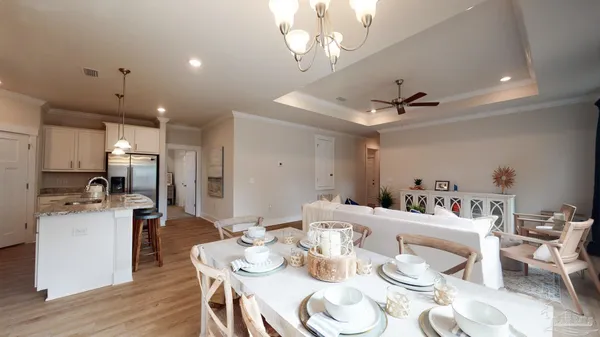 a kitchen with stainless steel appliances kitchen island granite countertop a dining table and chairs with wooden floor